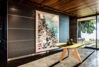 Here, a Jean Prouve-inspired entry table sits in front of a large-scale photograph by Massimo Vitali.