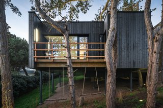 The deck of Atelier Victoria Migliore's tree house in France has two swings attached.