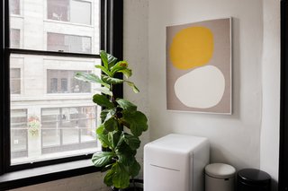 LaValle worked with a good friend and colleague Sarah Hurt of Seattle Art Source to find pieces for the studio, many of them by local artists. In a corner of the kitchen, a piece by the Portland, Oregon–based Mia Farrington hangs above a Daewoo fridge and trashcans by Brabantia.