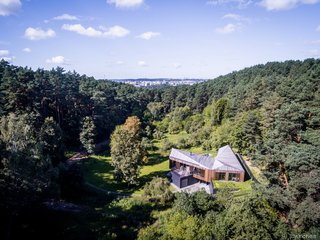 Valley Villa is located in a regional park outside Vilnius, Lithuania, on the site of a former wooden farmstead. The new 4,467-square-foot home has two wings on the upper level, one public and one private, which hosts three bedrooms and two-and-a-half baths. The lower level holds a garage, office, family room, and guest room.