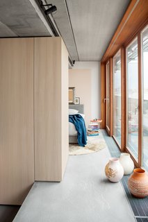 The bedroom is tucked behind the oak kitchen unit and is also bordered by floor-to-ceiling glass doors that open onto a terrace.