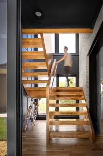 Wu brought the exterior materials inside, combining the maple plywood on the stairwell with the brick and board-and-batten.