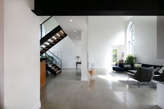 The altar-end of the building was also enclosed to form the boundary for the living room, with the attached office and workshop behind the wall on the lower level.  The upper level walkway to the master suite provides a sense of definition in the expansive space, which is 28 feet high at its peak.