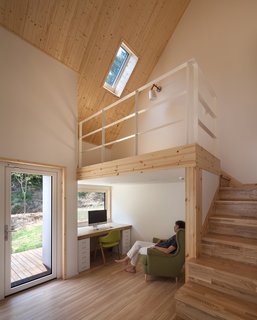 A bedroom with a built-in work space and a raised platform.