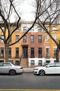 For the new entry, the team installed custom double doors topped with a transom. The stoop and door header are new constructions that matches the home’s original style. Black paint on the exterior trim looks sharp against the preserved facade.