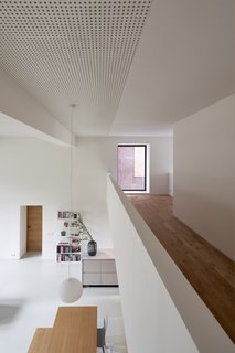 The view from the mezzanine to the main floor. Sound-absorbing plasterboards on the ceiling modulate the acoustics in the home. "I also like how we used the sound-absorbing ceiling in this project," says Elklund. "Next to being very functional for such a space, it adds texture and rhythm in a subtle way."