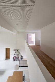 The view from the mezzanine to the main floor. Sound-absorbing plasterboards on the ceiling modulate the acoustics in the home. “I also like how we used the sound-absorbing ceiling in this project," says Elklund. "Next to being very functional for such a space, it adds texture and rhythm in a subtle way."