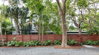 “Most homeowners would tear the whole thing down and start fresh,” says Brillhart. “But it made for a much more interesting project, preserving a little bit of Russell’s legacy and then adding two new wings on each side of the building.” An Ipe fence now lines the front of the property, and the two-story wing can be just glimpsed through the trees on the left.