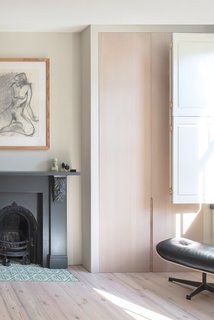 Now, bespoke wardrobes by Grovecourt flank the fireplace, which was newly painted. Hearth tiles are from Bert and May.