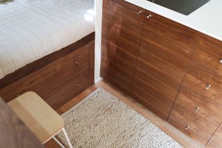 The bed platform can be lifted up to access a carpeted storage cavity beneath it, as well as a water heater, converter, and batteries. Two deep dresser drawers have built-in dividers, and thanks to The Modern Caravan’s attention to detail, the cabinetry fronts are beautifully grain-matched. 