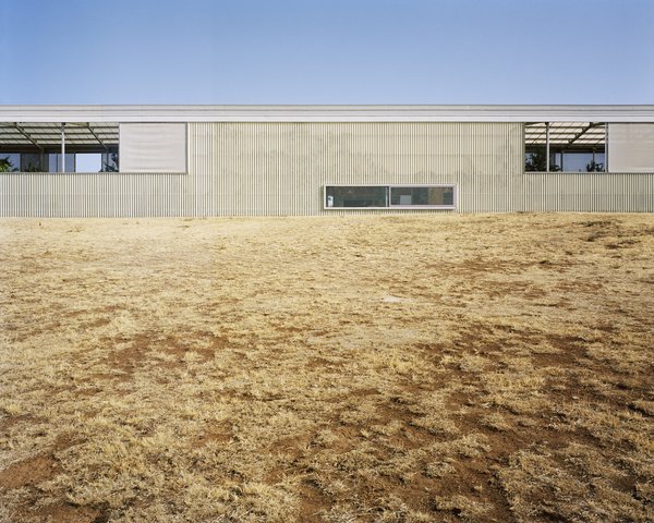 The Longhouse is clad in Ampelite fiberglass-reinforced polycarbonate sheeting. Per the firm: "The smart gel-coated cladding provides different levels of UV and infrared resistance, and panels with different finishes have been deployed to optimize solar penetration and shading depending on the orientation of each facade and roof plane." This cools temperatures in summer and keeps warmth in winter.