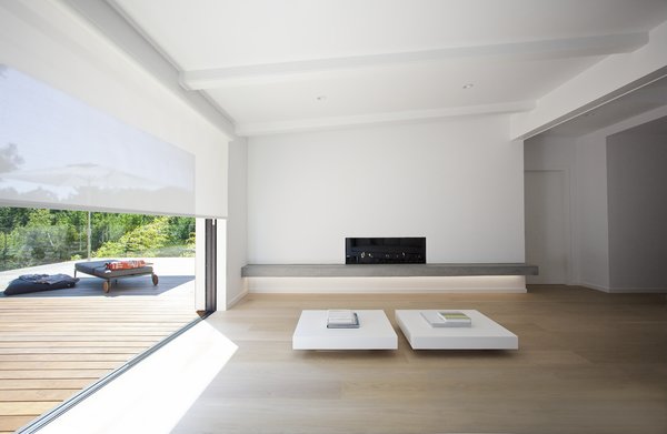 Huge header beams and thickened walls allow for a generous opening between the living room and deck, with doors that recess into the wall cavity and a seamless meeting between the indoor floor and the exterior decking.