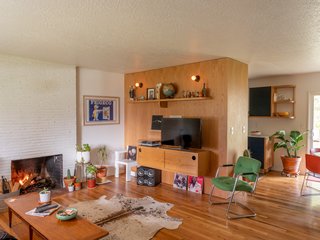 A new wood-panel wall is a focal point in the open layout. The original white oak floors were also refinished.