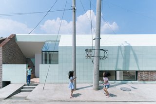 The tile-clad addition sits in the former yard of the wedding room, and now hosts the entry, dining room, and kitchen.