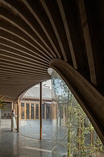 "The newly built veranda adopts a frame structure, with ribbed beams and panels on the ceiling, in order to maximize transparency and lightness as well as to better blend into the old construction," says the firm.