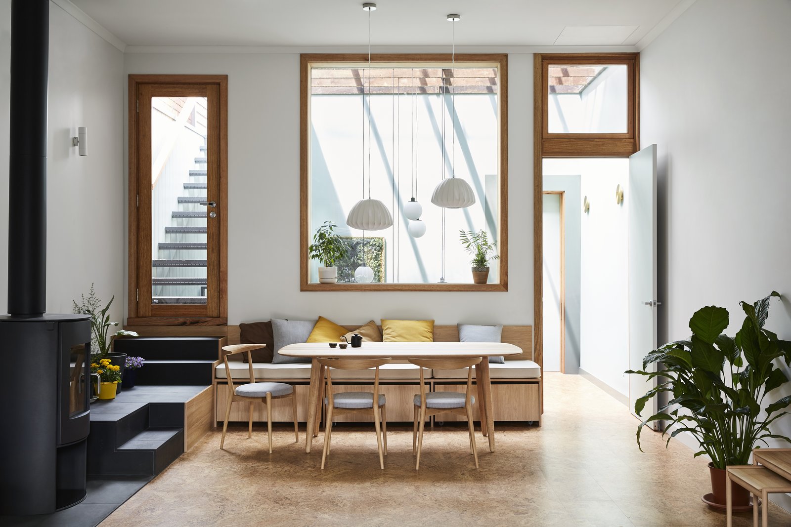 Tsai Design relocated the bedroom. In its place are the main living areas, including the dining room seen here. A built-in bench tucks neatly beneath the interior window. 