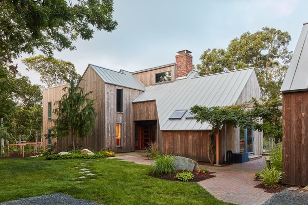 The team removed the outdated exterior detailing and replaced it with vertical strips of Kebony Clear siding and a Freedom Gray copper standing seam metal roof. 