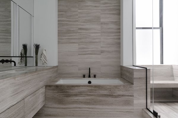 The bathroom layout was reconfigured for more privacy, and wrapped in honed beige marble.