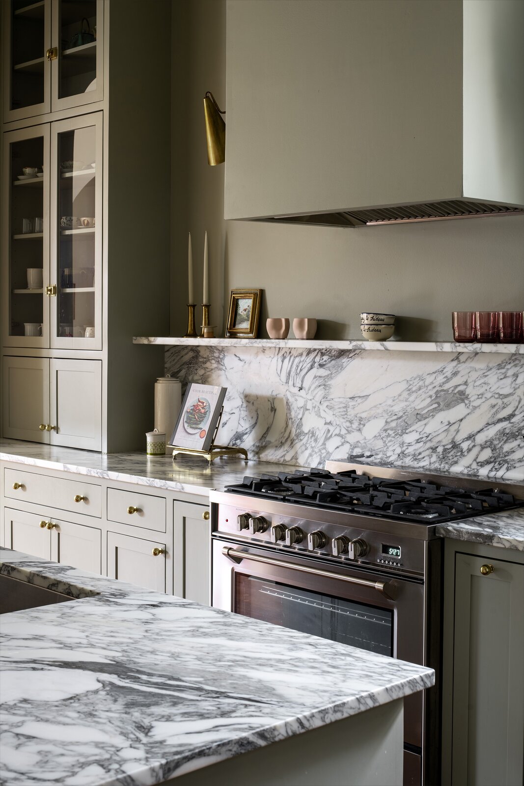 Farrow &amp; Ball French Gray covers the kitchen cabinetry, fabricated by Toulouse St. Millwork, walls, ceiling, and stove hood. The counters are Arabescato honed marble.