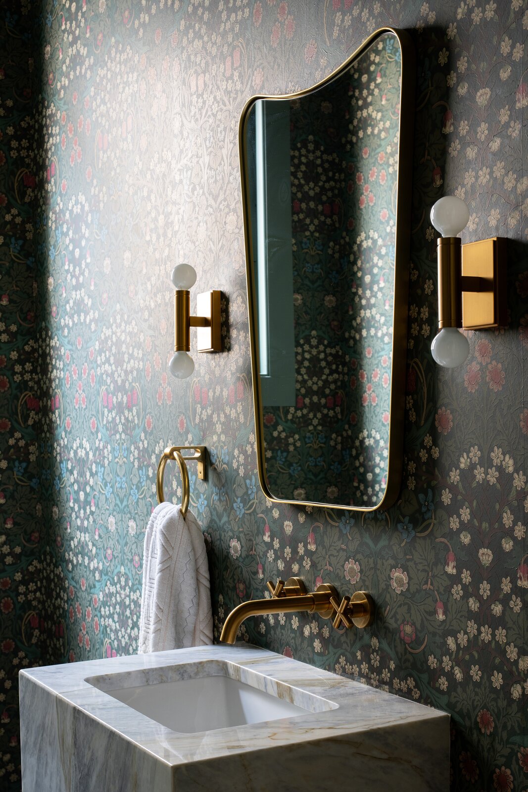 The new powder room has Blackthorn wallpaper from Morris &amp; Co, which was chosen for how its green and pink palette 