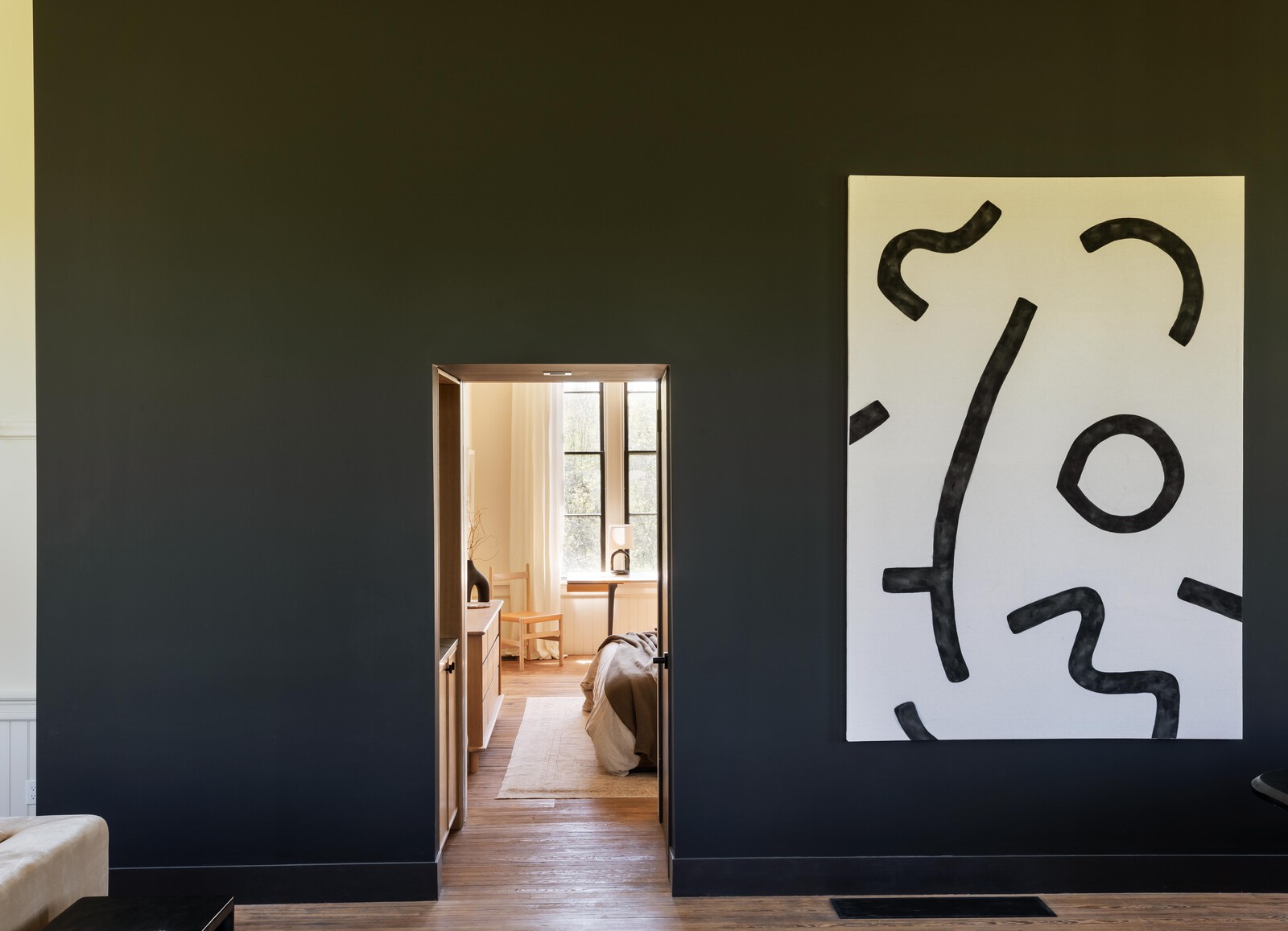 A vestibule at the entrance to the primary suite has a bar and access door to the basement.