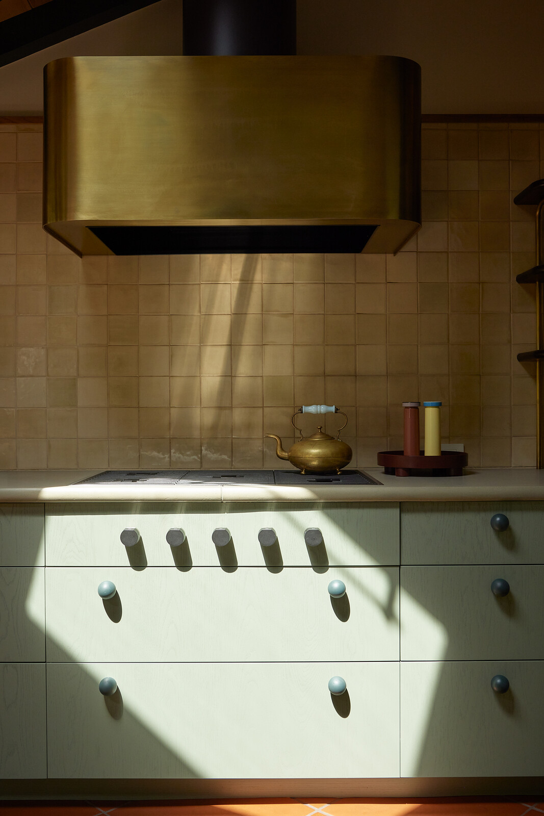Boy Boy fabricated the brass shelving and custom range hood. The backsplash tile is by Portland studio Tempest Tileworks.
