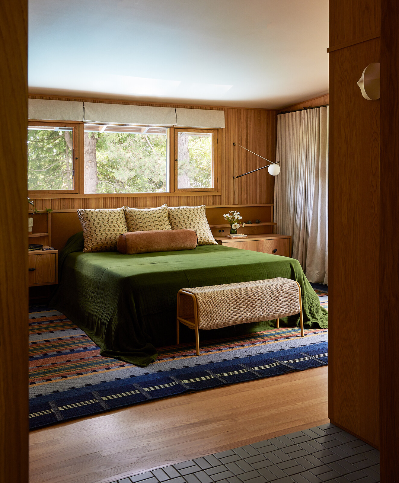 The built-in oak bed and wall treatment was designed by Bright Designlab and fabricated by Master Furniture Makers, with a custom colorful rug designed by Bright Designlab, in collaboration with Kush Rugs.