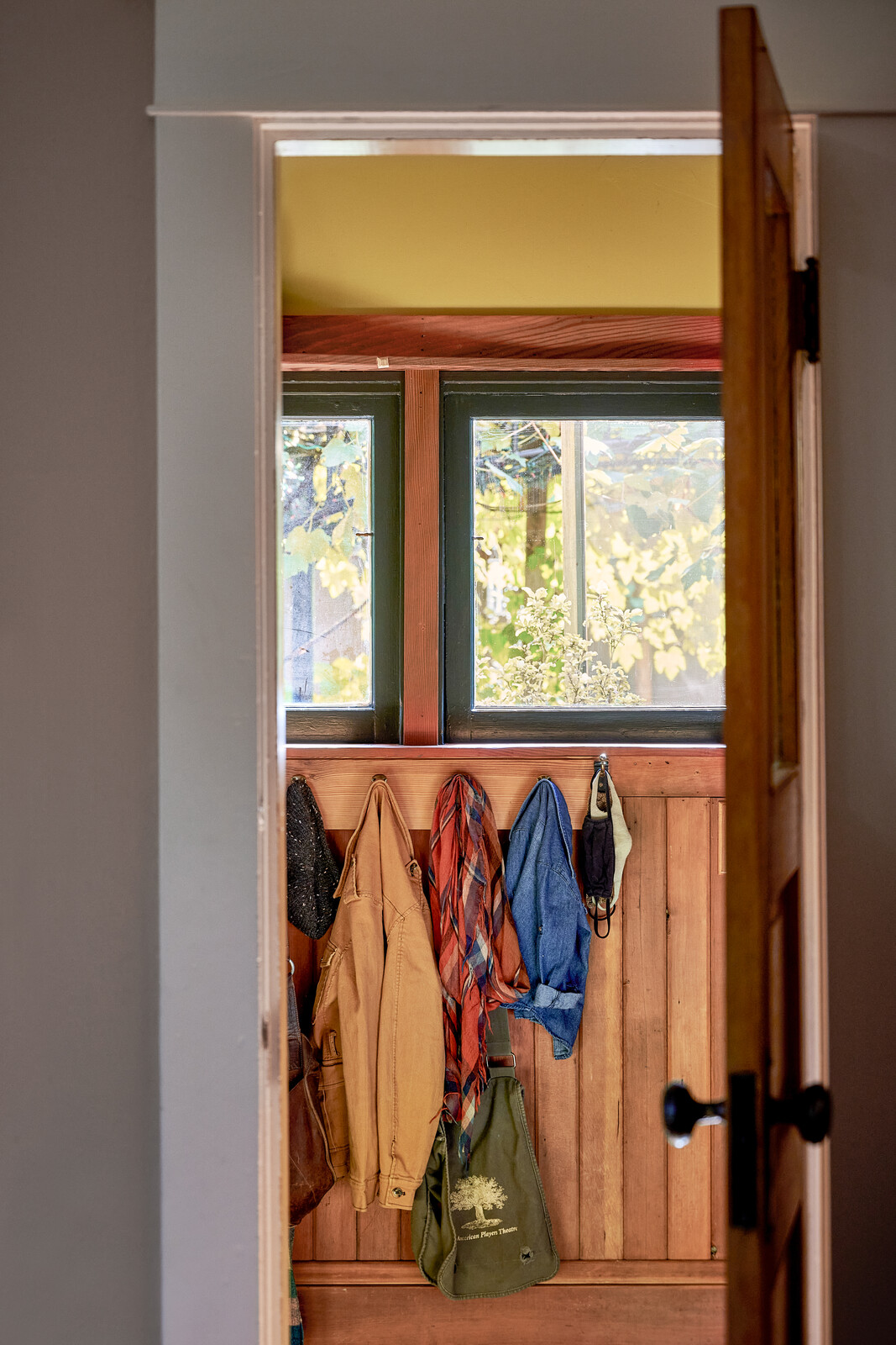 The existing tongue-and-groove paneling in the mudroom that's seen here inspired the backsplash and select cabinet fronts in the kitchen remodel. The couple kept the windows and painted the frames Benjamin Moore "Regent Green."