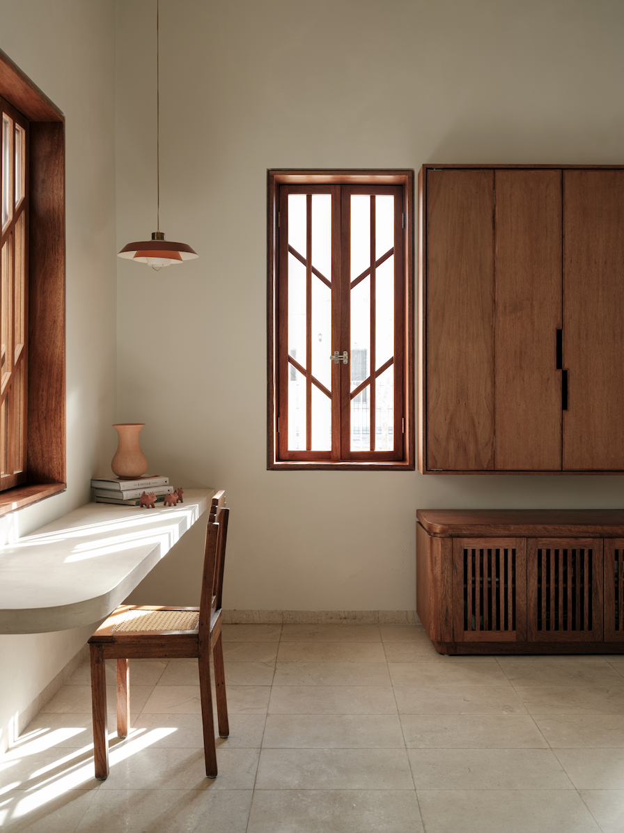 In the living room, an integrated desk with a vintage light and cabinet designed by FMT Estudio.
