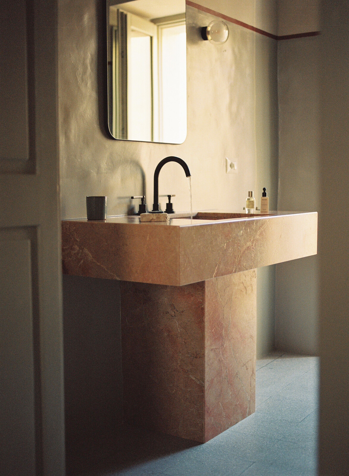 Manuel designed the pedestal sink and had the consulting architect make specified plans for it. The stone is Italian red marble, called Rosso Tramonto.