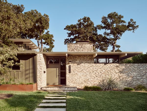The architect removed the clunky addition enclosing the front door and reinstated the original door and sidelites. New and restored board-and-batten siding is painted Roycroft Bronze Green by Sherwin Williams.