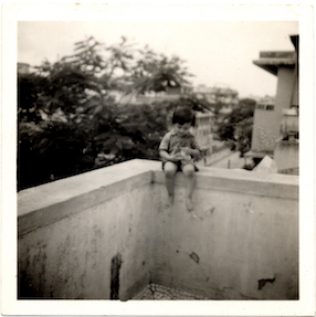 Vineet Vora on the apartment's balcony ledge with the Rain tree in the background, circa 1988.