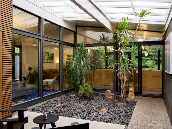 Workaday Design reinstated the full glass panel on the kitchen side of the atrium, and John and Nadia had the concrete pad refinished.