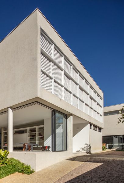 Architect Ana Sawaia restored the screens to their original color, and swapped in stacking glass doors on the main level so it opens seamlessly to the garden.