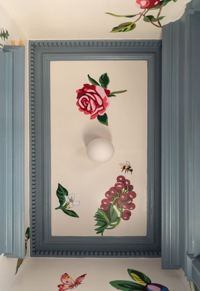 The mural was inspired by an heirloom cabinet belonging to the German husband. "It has a flower detail on it that we wanted to reinterpret in an American aesthetic,
