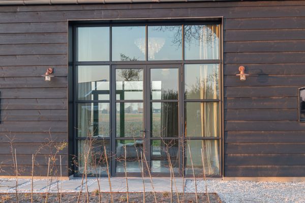 The exterior siding is pine planks finished in black paint from Tikkurila Vinha.