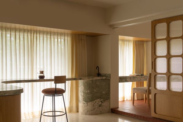A sliding door separates Nikita's study from the main room. The bar chair is custom by Kaviar Collaborative.