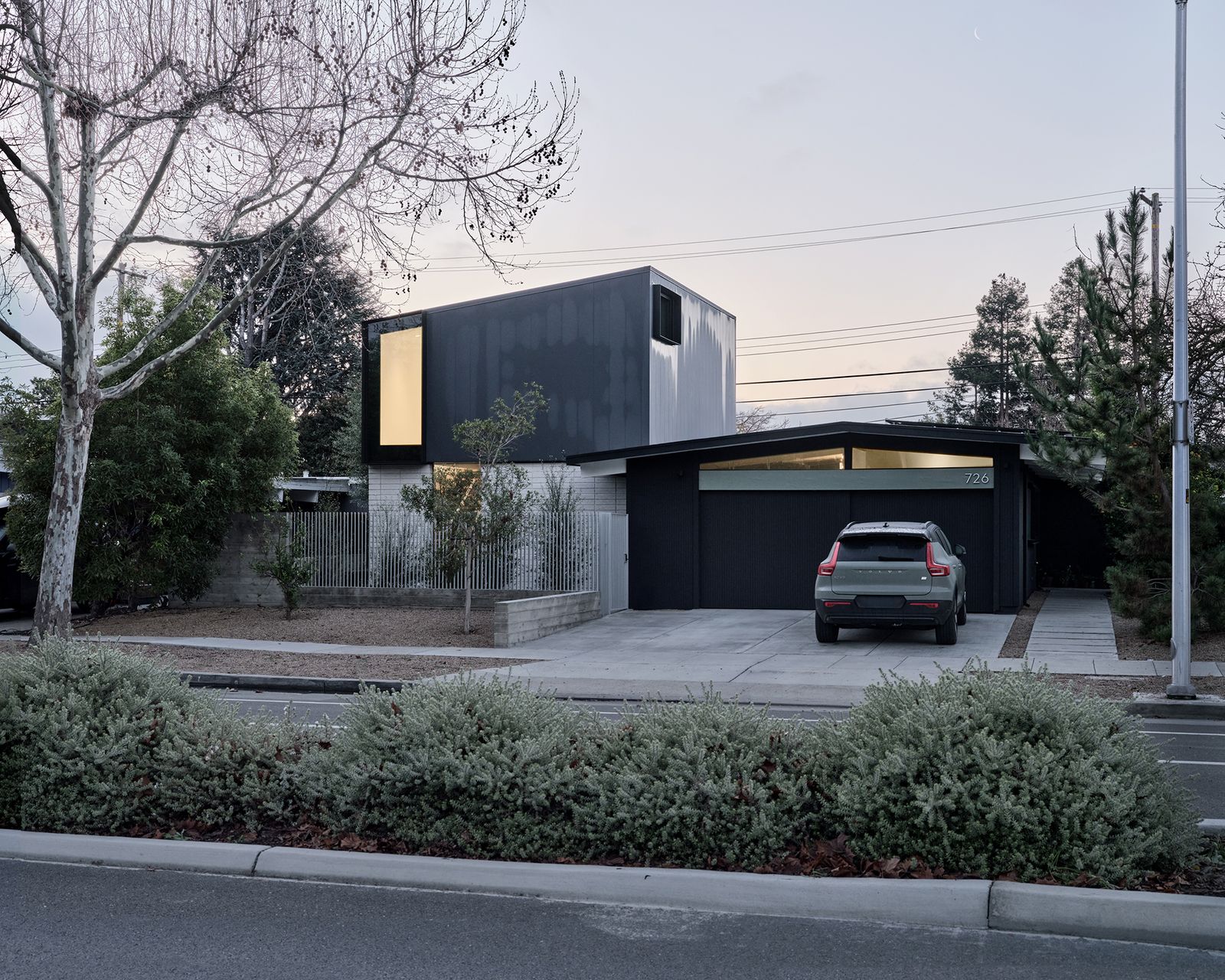 The addition has two different exterior materials, concrete block to reference the house's midcentury roots and standing seam metal at the top. Inside, there's a family room on the lower level and a primary suite upstairs.
