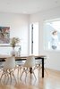 The dining area is positioned off of the kitchen and next to the living area to create open, flexible space. Behind the dining table, open stairs lead down to the family room on the ground floor. A small roof deck is also accessible off the dining area. Photo 6 of Chenery Street Remodel modern home
