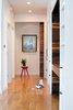 A full wall of built-in storage cabinets accented with walnut and oil-rubbed bronze hardware. A large walnut sliding barn door leads to the master suite and office areas. Photo 5 of Chenery Street Remodel modern home