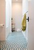Modern home with Bath Room, Ceramic Tile Floor, and Subway Tile Wall. An existing lightwell was filled-in to create space for a concealed laundry area at the rear of the main bathroom. Soft natural light pours in from the skylight over the tub. Photo 8 of Chenery Street Remodel
