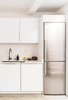 Modern home with Kitchen, Undermount Sink, White Cabinet, Refrigerator, Dishwasher, Range, Engineered Quartz Counter, Ceiling Lighting, Concrete Floor, and Range Hood. A built-in Liebherr refrigerator pairs well with the bright white cabinets and concrete floors. Photo 3 of 21st Street Cottage Remodel