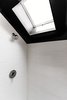 Modern home with Bath Room, Enclosed Shower, Ceramic Tile Wall, Accent Lighting, One Piece Toilet, Ceramic Tile Floor, and Wall Lighting. A skylight brings in natural light and creates the feeling of a higher ceiling in the shower. Photo 13 of 21st Street Cottage Remodel