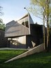 looking S: sloped 2nd floor wall & glazing. concrete retaining wall designates street entry. applied aluminum sheet (leftovers from soffits) on front door. Photo 3 of metalHOUSE(2) modern home