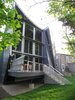 SOUTH ELEVATION looking NE: elevated living space to meet code. passive solar elements…¼” bent aluminum plate sunshades, overhang. the railing system uses aluminium angle & tube armature, perforated aluminum panels, stainless steel cable. 1 x 6 trex decking on the walking surfaces. the “slit glazing” resembling a pair of “tweezers” grabs the late PM light. Photo 4 of metalHOUSE(2) modern home