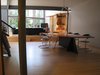 looking S from entry: “grasshopper” dining room table seats 12. mdf board w/plastic laminate, oak plywood, aluminum angle & bar, skinny steel legs like a grasshopper’s. all of the major interior materials are incorporated into this piece. FYI, most of the interior furnishings were built on site. overhead lighting by artemeide. living room media center beyond. Photo 7 of metalHOUSE(2) modern home