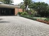 Modern home with Outdoor, Front Yard, Trees, Flowers, Hardscapes, Gardens, Shrubs, Walkways, and Horizontal Fences, Wall. Burle Marx signature plants include the fernlike Brazilian tower tree, turquoise blooming jade vine, Philodendron Burle Marx used as a groundcover, and specimen bromeliads such as Dyckia Burle Marx. Brightly colored foliage is used in large contrasting blocks. Photo of Mid-Century Modern Bungalow