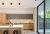 Modern home with Kitchen, Engineered Quartz Counter, Wood Cabinet, Concrete Floor, Recessed Lighting, Accent Lighting, Porcelain Tile Backsplashe, Cooktops, and Undermount Sink. Kitchen Photo 19 of Pavilion Haus