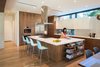 Modern home with Kitchen, Wall Oven, Engineered Quartz Counter, Undermount Sink, White Cabinet, Wood Cabinet, Refrigerator, and Light Hardwood Floor. Interior View Photo 7 of McClendon Residence