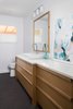 This hall bathroom features a beautiful white oak vanity cabinet and custom mirror designed by Jameson Interiors and built by A. R. Lucas Construction. Photo 7 of St. Johns House modern home